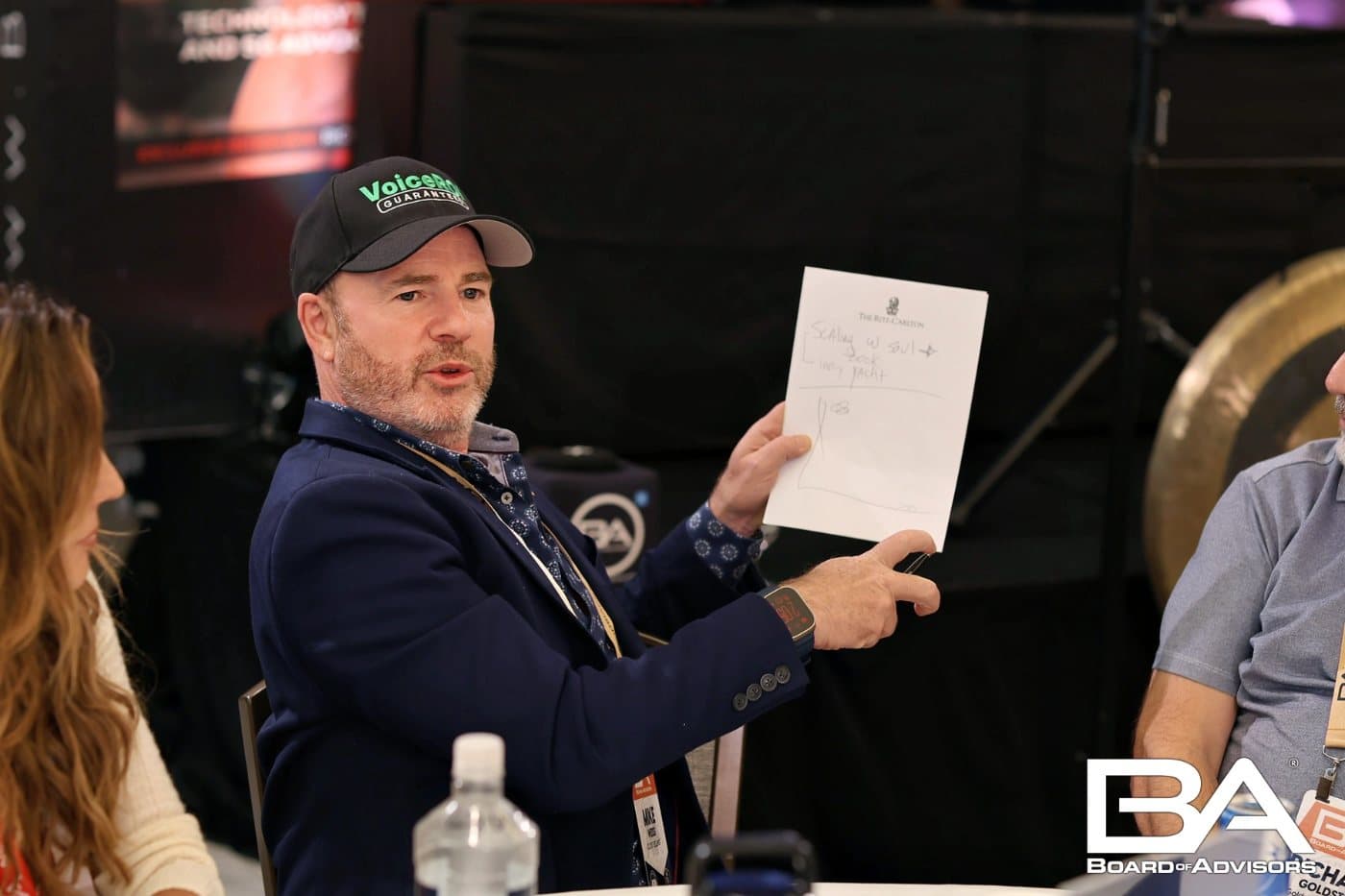 Mike Weiss holding up a handwritten page at a Board of Advisors table