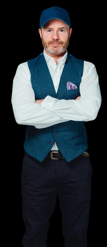 Mike Weiss in a blue cap and teal vest, arms crossed