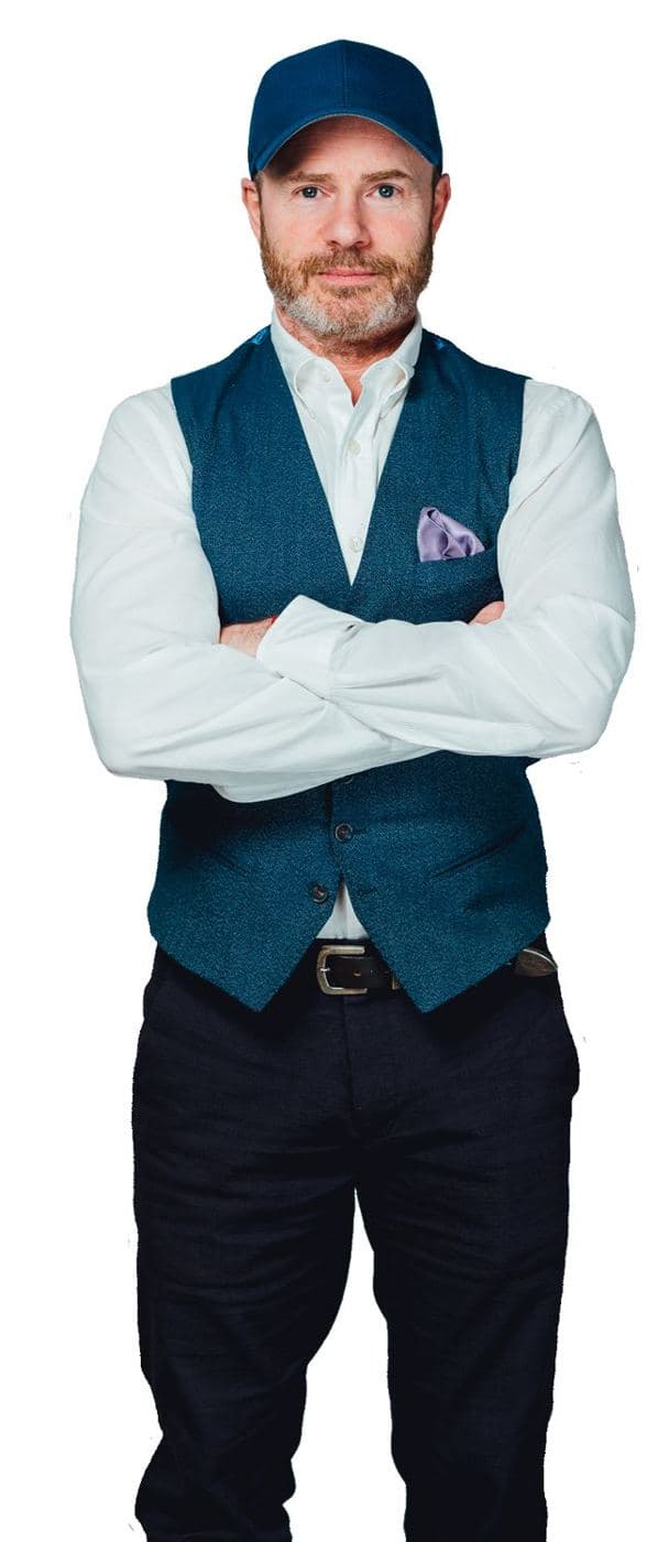 Mike Weiss in a blue cap and teal vest, arms crossed